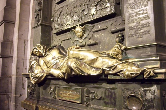La estatua de T'serclaes; se supone que tocarla (o m�s bien frotarla) concede deseos, por lo que el cuerpo en la estatua y otros objetos como la cara de un �ngel, un perro, y un escudo, est�n mucho m�s brillantes que el restoThe statue of T'serclaes; it is said that touching (or rather rubbing) the statue grants wishes, so the body in the sculpture and other objects such as the face of an angel, a dog, and a shield, are much brighter than the rest